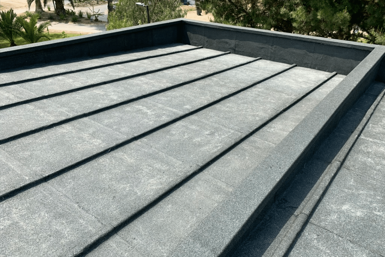 Cubierta impermeabilizada con membrana asfáltica gris en azotea plana.