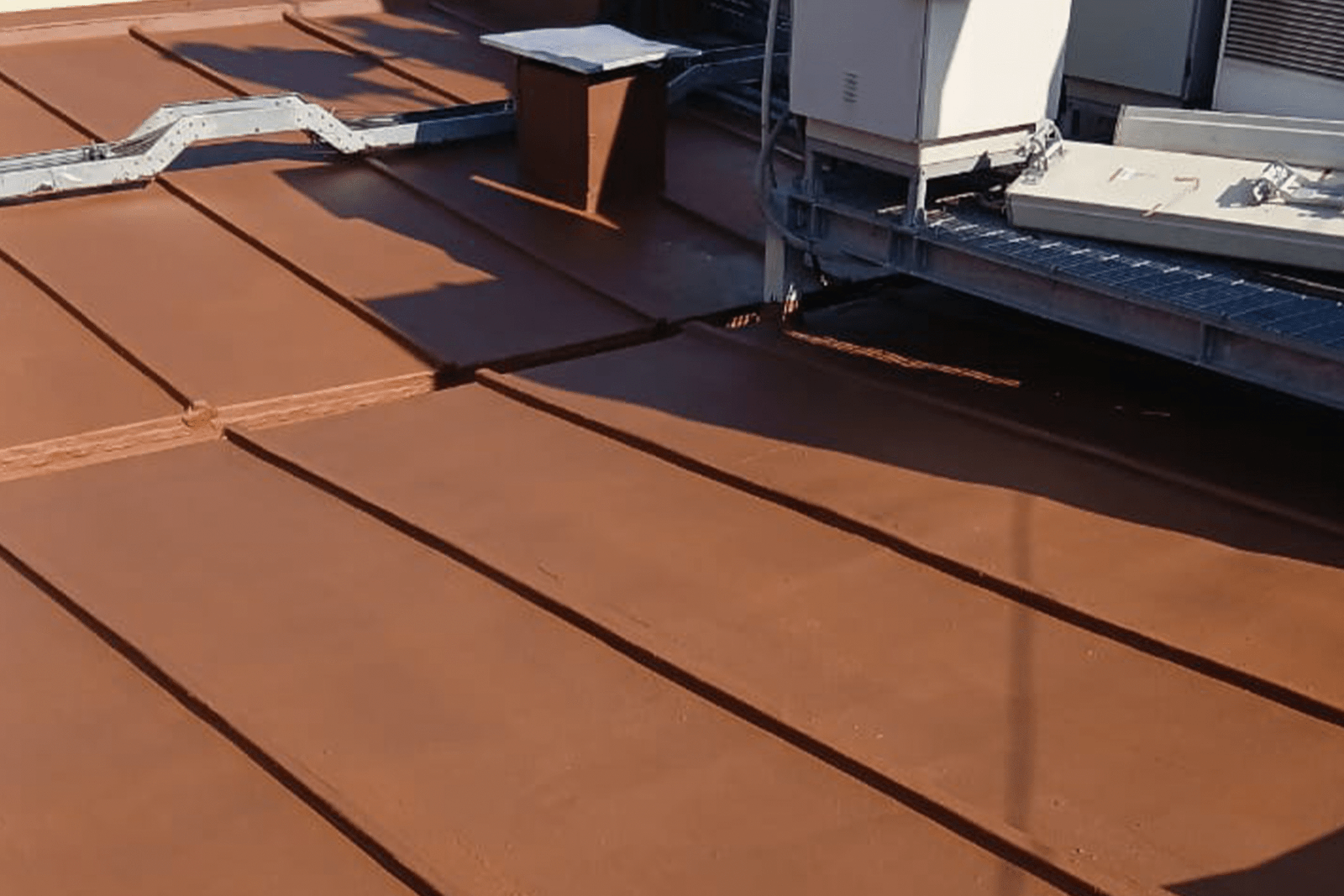 Cubierta impermeabilizada con membrana líquida color café en techumbre con equipos técnicos.