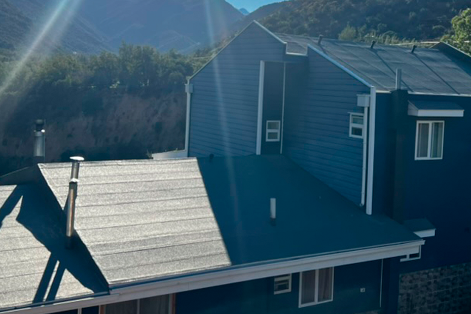 Casa con techumbre impermeabilizada con membrana asfáltica en zona residencial de montaña.